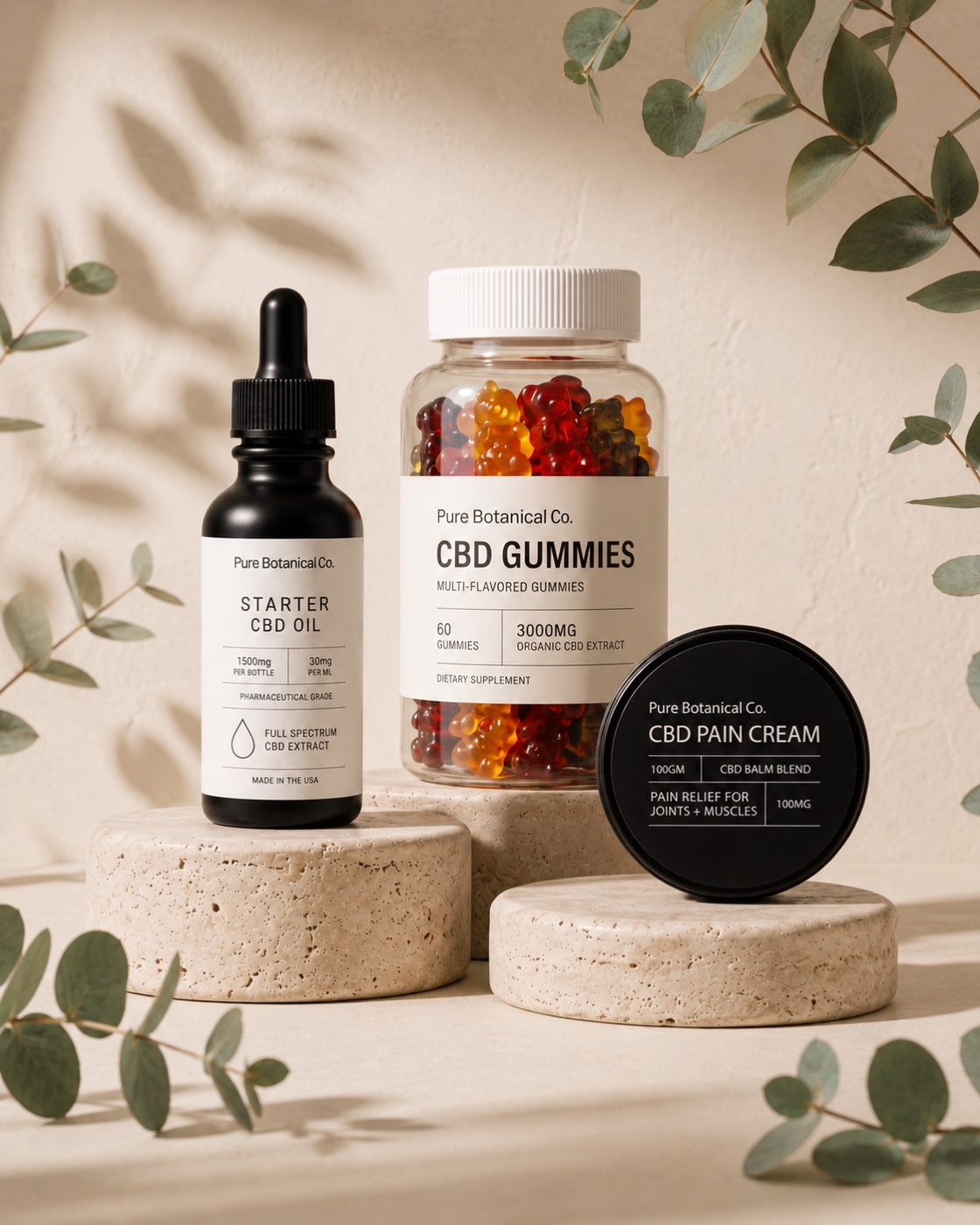 Pure Botanical Co Everyday Trio: Starter CBD Oil, CBD Gummies, and CBD Pain Cream on stone with eucalyptus